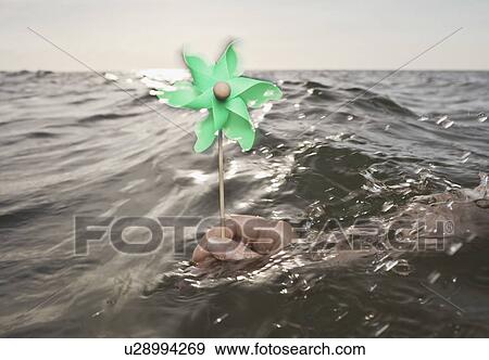 Arm holding windmill towards sea View Large Photo Image Stock Photo - Arm holding windmill towards sea. Fotosearch