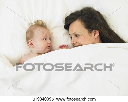 Stock Photography - baby and mother in bed. Fotosearch