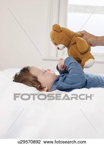 Baby looking at teddy bear View Large Photo Image Stock Image - Baby looking at teddy bear. Fotosearch
