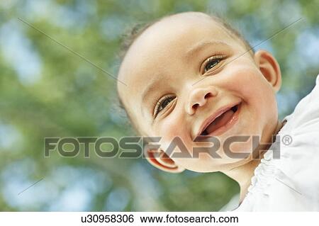 Baby smiling looking down at camera View Large Photo Image Stock Photograph - Baby smiling looking down at camera. Fotosearch