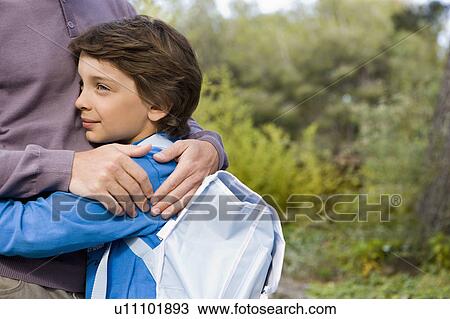 boy cuddling dad back from school View Large Photo Image Stock Image - boy cuddling dad back from school. Fotosearch