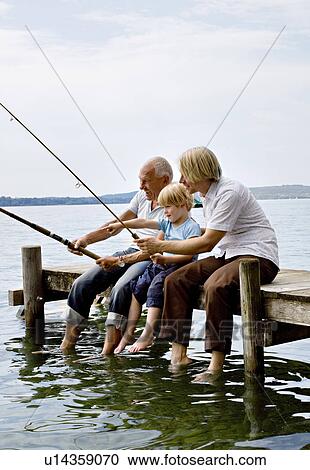 Stock Image - boy fishing with grandfather, father. Fotosearch