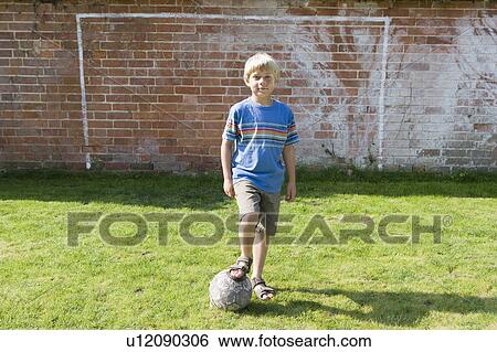 Stock Photograph - Boy in front of goal. Fotosearch