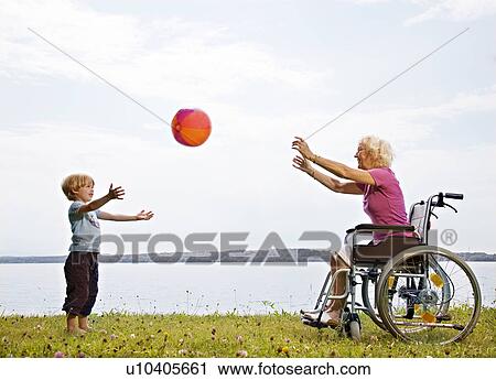 Stock Image - boy playing ball with senior woman. Fotosearch