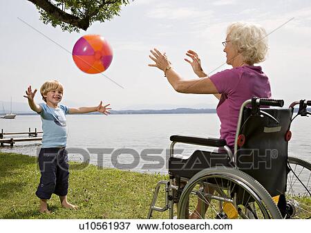 Stock Photo - boy playing ball with senior woman. Fotosearch