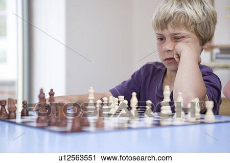 Stock Image - Boy playing chess. Fotosearch