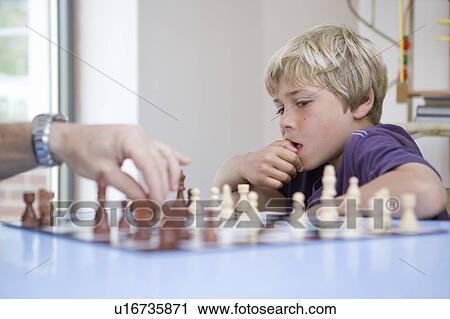 Stock Image - Boy playing chess. Fotosearch