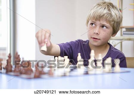 Stock Image - Boy playing chess. Fotosearch