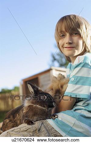 Boy playing with rabbit in garden View Large Photo Image Picture - Boy playing with rabbit in garden. Fotosearch