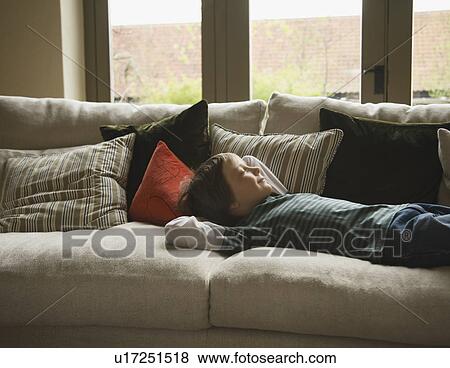 Stock Photo - Boy relaxes on sofa. Fotosearch