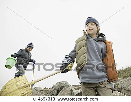 Stock Image - Boys on beach rocks. Fotosearch