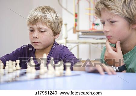 Stock Image - Boys playing chess. Fotosearch