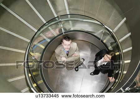 Business couple in a spiral stairwell View Large Photo Image Stock Photography - Business couple in a spiral stairwell. Fotosearch