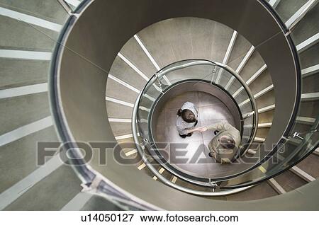 Business duo shake hands in a stairwell View Large Photo Image Stock Photo - Business duo shake hands in a stairwell. Fotosearch