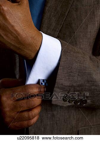 Stock Photo - Business man adjusting cuff links. Fotosearch