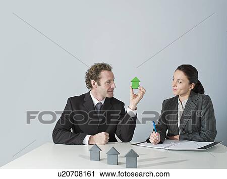 Stock Image - Business man discusses housing. Fotosearch