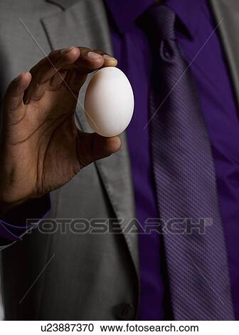 Business man holding egg View Large Photo Image Stock Image - Business man holding egg. Fotosearch