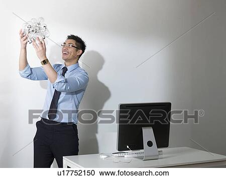 Business man holding Light bulbs View Large Photo Image Stock Image - Business man holding Light bulbs. Fotosearch