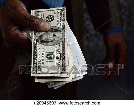 Business man holding out dollar bills View Large Photo Image Stock Photo - Business man holding out dollar bills. Fotosearch