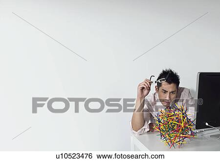 Stock Photograph - Business man looking at a sculpture. Fotosearch