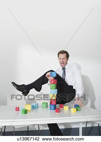 Business man puts last block on tower View Large Photo Image Stock Image - Business man puts last block on tower. Fotosearch