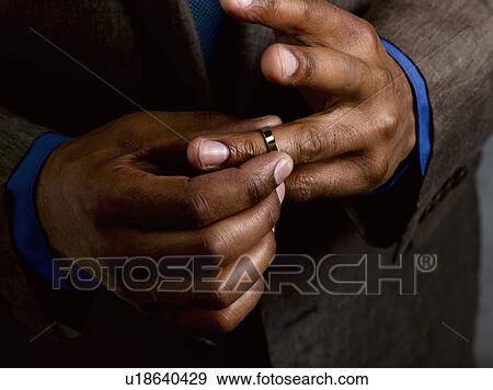 Stock Photo - Business man putting on wedding band. Fotosearch