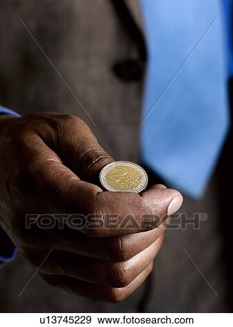 Stock Photo - Business man ready to flip euro coin. Fotosearch