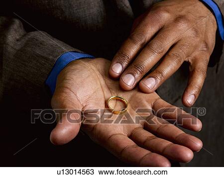 Stock Image - Business man showing wedding band. Fotosearch
