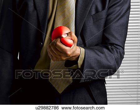 Stock Photograph - Business man squeezing stress ball. Fotosearch