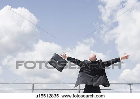 Stock Photography - business man throwing arms in the sky. Fotosearch