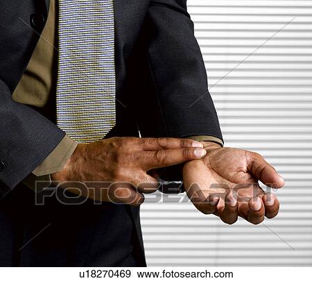 Stock Photo - Business man with finger on pulse. Fotosearch