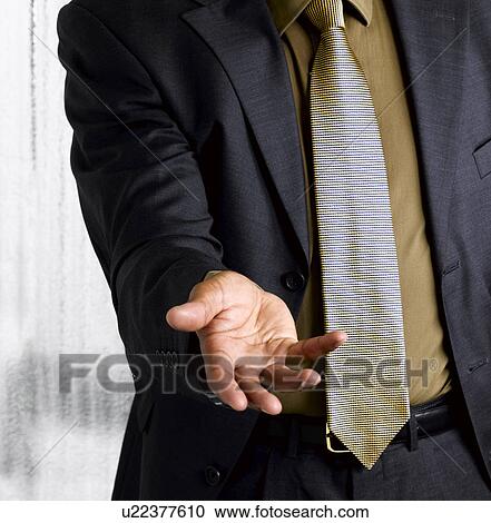 Stock Image - Business man with open hand out. Fotosearch