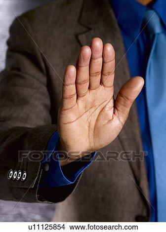 Picture - Business man with palm to camera. Fotosearch