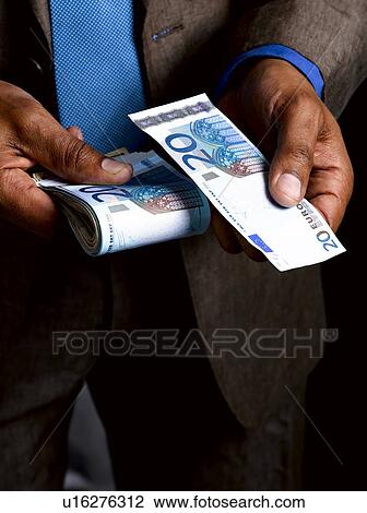 Business man with wad of euro bills View Large Photo Image Stock Image - Business man with wad of euro bills. Fotosearch