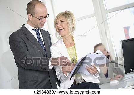 Stock Photo - Businessman and laughing woman standing. Fotosearch