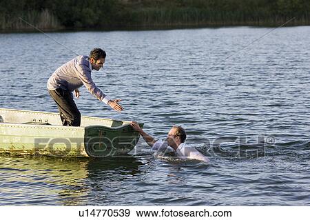 Stock Photo - businessman helping man overboard. Fotosearch