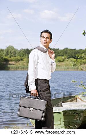 Stock Image - businessman in front of rowboat. Fotosearch