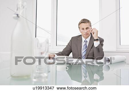 Businessman looking at some plans View Large Photo Image Stock Photo - Businessman looking at some plans. Fotosearch