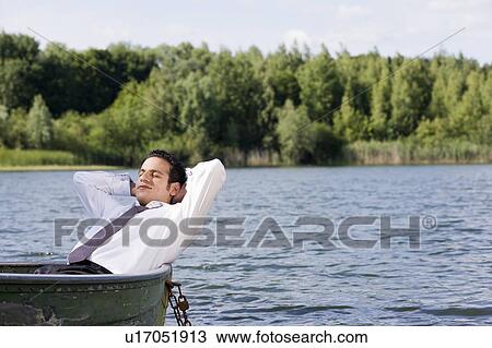 Stock Image - businessman lying in rowboat. Fotosearch