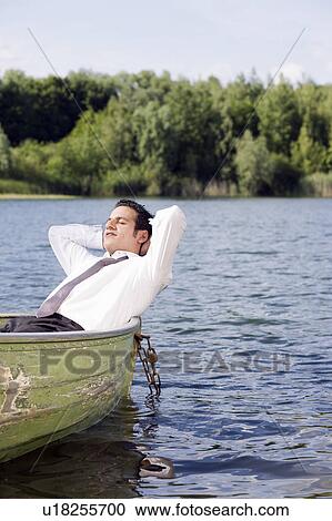 businessman lying in rowboat View Large Photo Image Stock Image - businessman lying in rowboat. Fotosearch