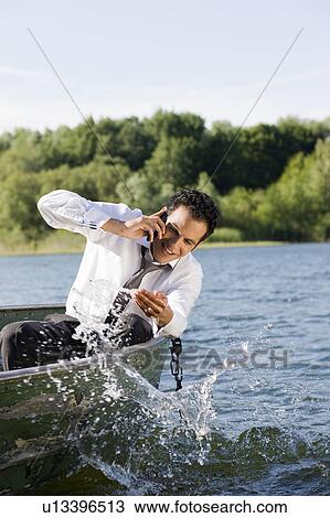 Stock Image - businessman on the phone in rowboat. Fotosearch