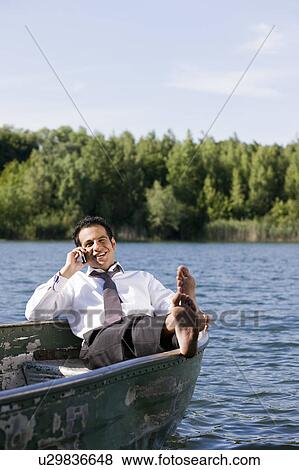 businessman on the phone in rowboat View Large Photo Image Stock Photo - businessman on the phone in rowboat. Fotosearch