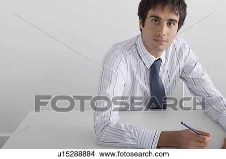 Picture - Businessman sitting at white table. Fotosearch