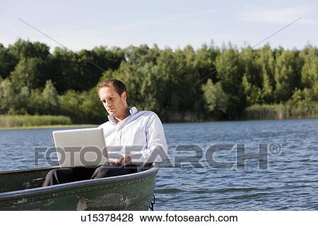 businessman with laptop in rowboat View Large Photo Image Stock Photo - businessman with laptop in rowboat. Fotosearch