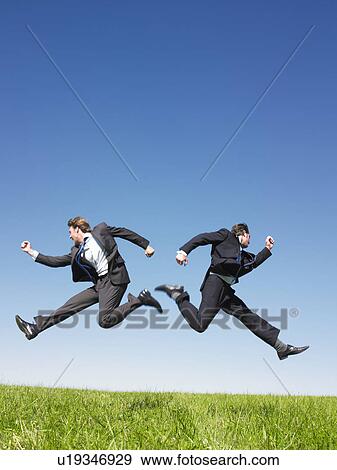 Stock Photo - businessmen jumping in field. Fotosearch