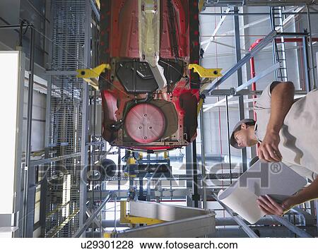Stock Photo - Car Plant Worker & Car From Below. Fotosearch