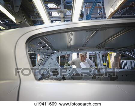 Stock Photo - Car Plant Worker Inspecting Car. Fotosearch