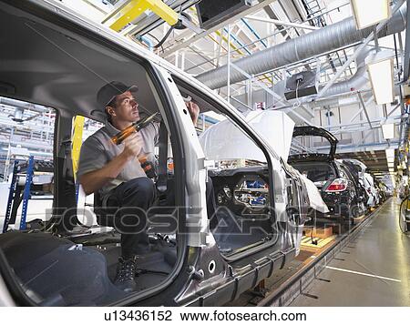 Stock Image - Car Plant Worker On Production Line. Fotosearch