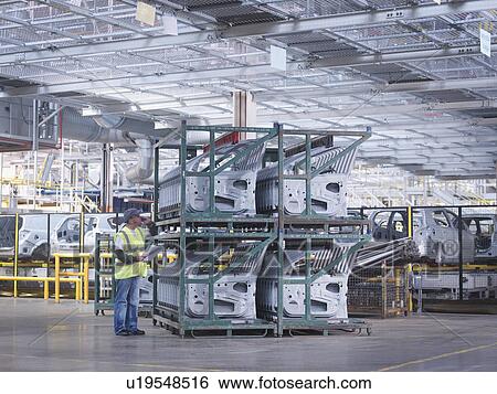 Stock Photograph - Car Plant Worker With Car Doors. Fotosearch