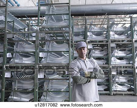Stock Image - Car Plant Worker With Car Parts. Fotosearch